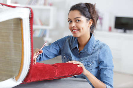 woman upholstering chair at homeの写真素材