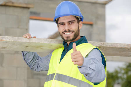 happy builder man laughing and making thumbs upの写真素材
