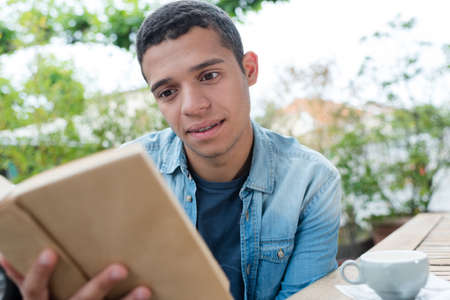 young man reading a bookの写真素材