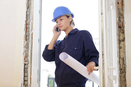 female architect holding papers in siteの写真素材