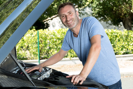 happy man fixing a car