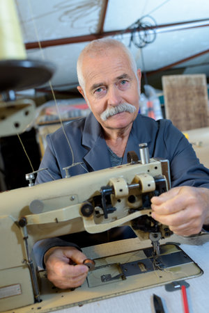 senior man using sewing machine