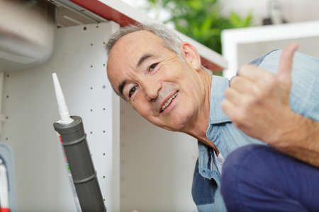 senior repairman working at the kitchenの写真素材
