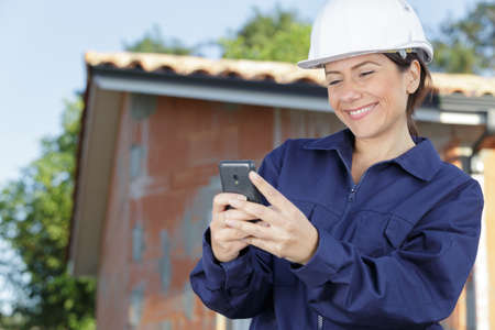 attractive woman builder using her phoneの写真素材