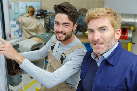 man teaching apprentice in workshop