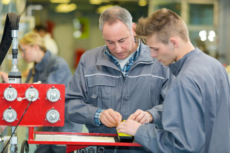 trainees learning with boss about wood measurement