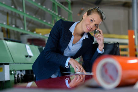 happy businesswoman talking by phone at warehouseの写真素材