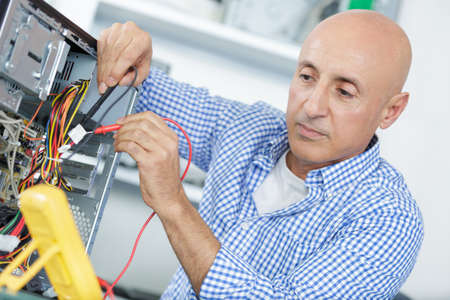 technician using voltage meter for voltage measurement in computerの写真素材