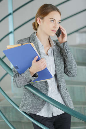 businesswoman holds documents and calling someoneの写真素材