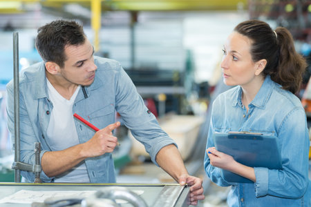 two workers discussing project in factory