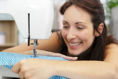 happy woman cutting and sewing
