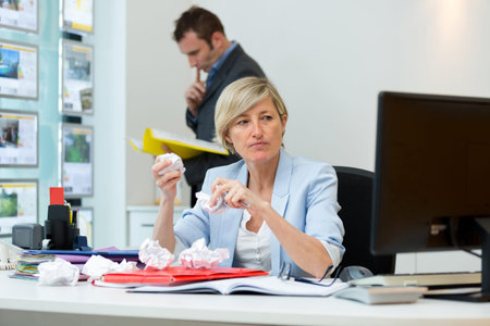 angry woman screwing up paper to throw at computer