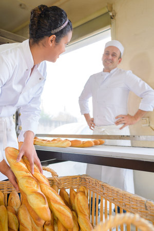 female baker loading bread into basket