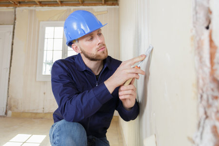 young plasterer plastering the walls