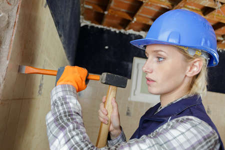 female builder with hammer and chiselの写真素材