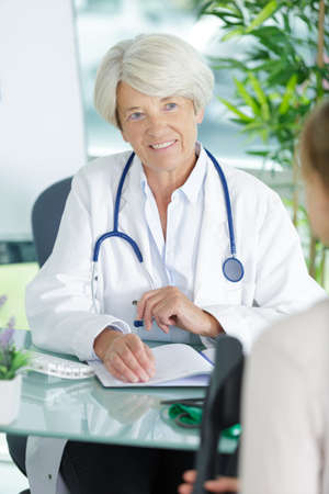 medical doctor woman talking to patinet in officeの写真素材