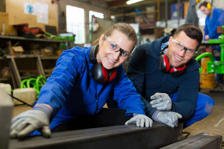 happy man and woman in factoryの写真素材