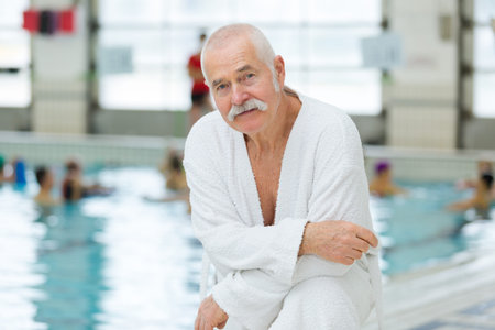 senior man looking at the camera indoor swimming pool