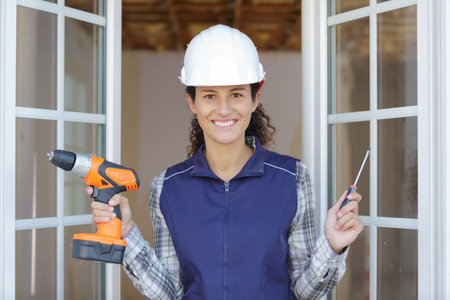 happy woman builder holding tools