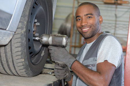car mechanic screwing or unscrewing car wheel