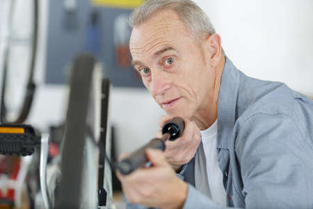 senior man pumping the wheel bikeの写真素材