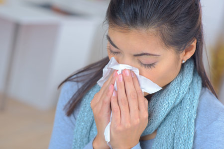 woman feeling sick and sneezing