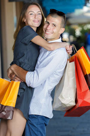 smiling attractive couple with shopping bags in the cityの写真素材