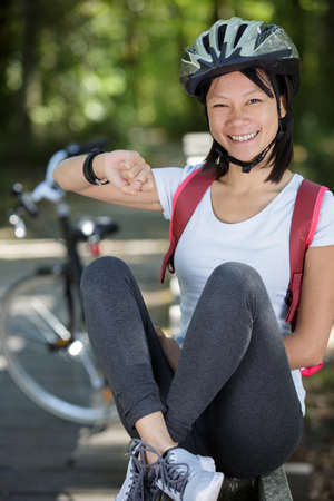 happy sporty woman using smart watch outdoors in parkの写真素材