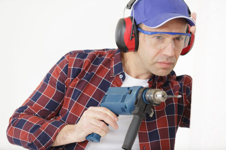 builder drills a hole in the wall