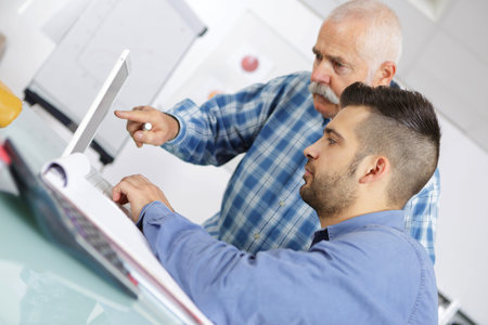 computer teacher assisting a student in classroom