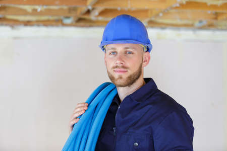 a male builder holding pipesの写真素材