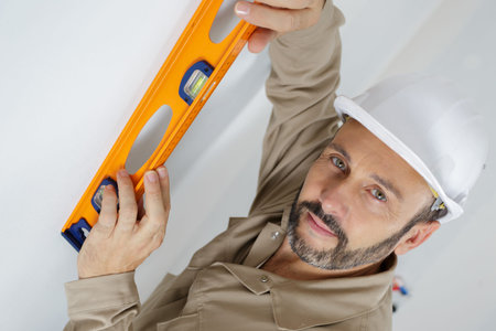 man posing with a builders level