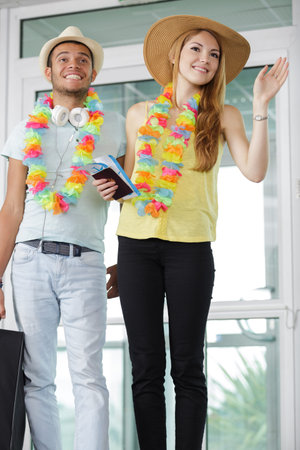 a couple waving as the arrive from holiday