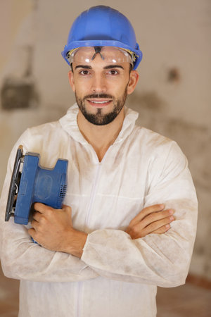 man with sander in hands