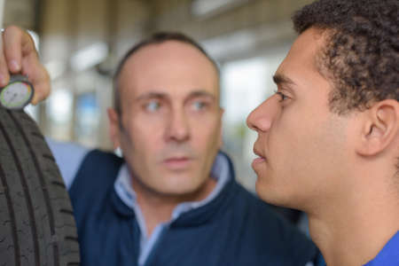 mechanic giving tire lesson to the apprenticeの写真素材
