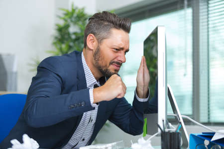 man almost punching the computer screenの写真素材