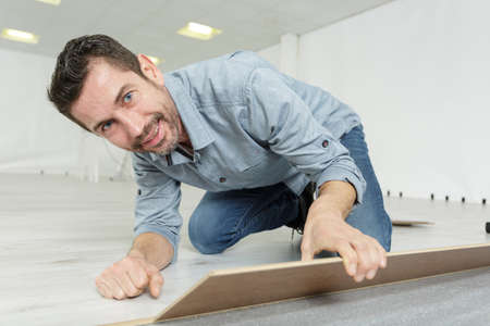 laminate flooring man in sneakers repairの写真素材
