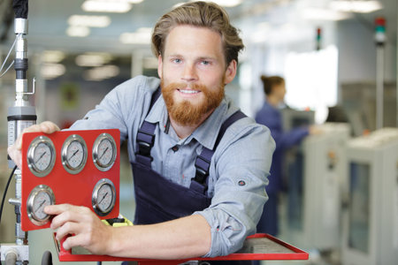 engineer pointing to one of the dials on a machine