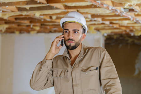 worker in overalls on mobile phoneの写真素材