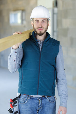 man as builder carrying wood and working