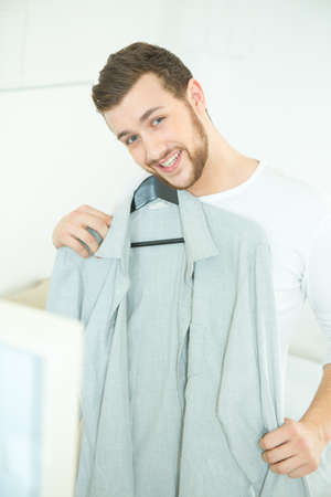man choosing shirt for himself in boutiqueの写真素材