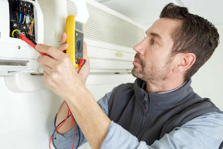 handyman repairman conducting residential hvac repairの写真素材