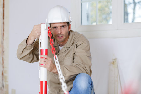 caucasian worker holding chain at construction site