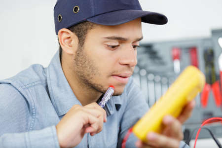 young electrician working with switchesの写真素材