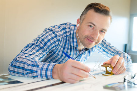 portrait of man wearing earphones while proof reading print