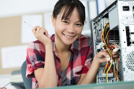 happy young female pc technician in classの写真素材