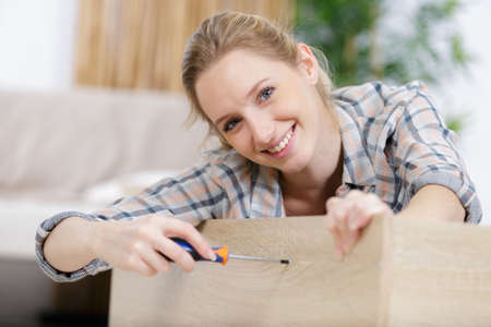 woman moving in holding screws and furniture partsの写真素材