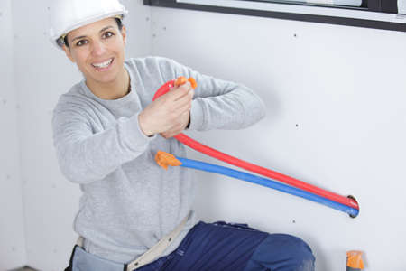 portrait of female builder holding pipesの写真素材