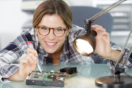 woman soldering elements of circuit board