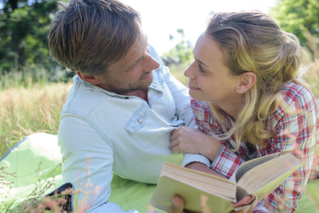 man and woman laying on the grassの写真素材